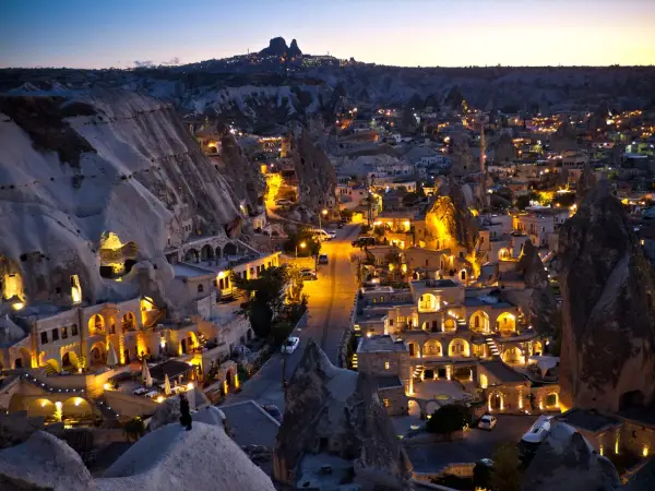 Göreme village at dusk with Uçhisar Castle on the horizon