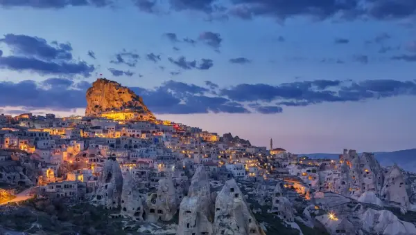 Uçhisar Castle and village lit up at dusk